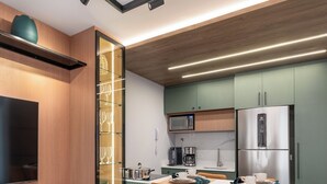 A modern kitchen with a dining area, featuring a built-in microwave, stainless steel refrigerator, and a coffee maker. - Decorated 2 bedroom apartment in the center (Centro Curitiba)