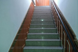 Una escalera con escalones de madera y barandilla de metal.