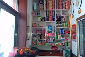 A store interior with shelves stocked with various products, a counter, and a display case. - Kailai Hotel (Mohe)