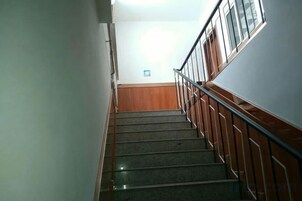Una escalera con barandilla y una barandilla de madera en el lado derecho.
