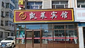 A hotel with a red and yellow signboard, large glass windows, and a white car parked in front. - Kailai Hotel (Mohe)