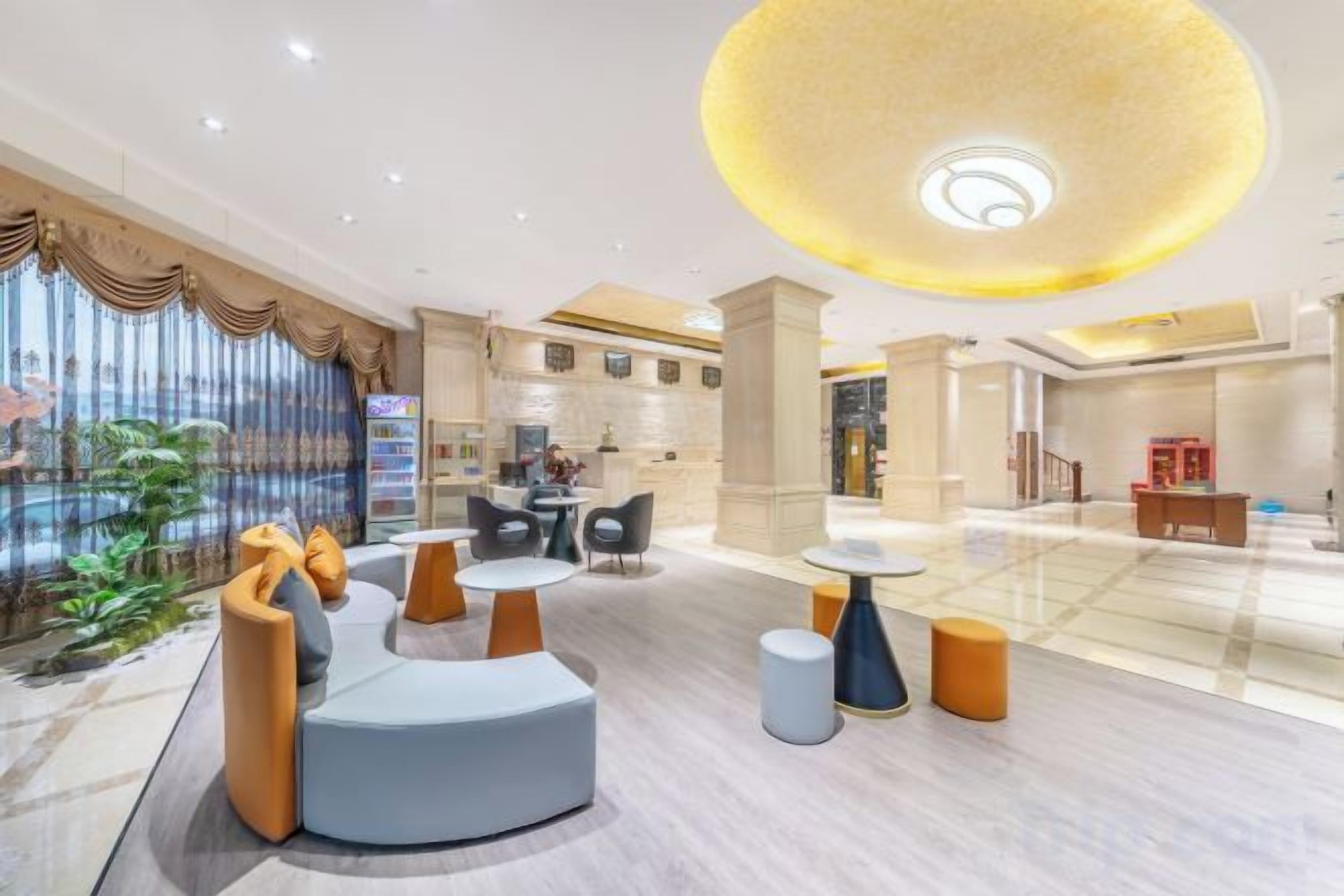 A modern lobby with seating areas, a pool view, and a central table.
