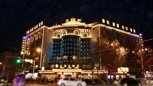 A multi-story building with illuminated signage and a prominent entrance. - Tian Zuan Wang Chao Hotel (Huai'an)