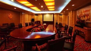 A conference room with a large oval table, multiple chairs, and a carpeted floor. - Tian Zuan Wang Chao Hotel (Huai'an)