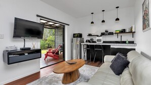 Ein modernes Wohnzimmer mit einem Holztisch, einem weißen Sofa und einem flachbildfernseher an der Wand.