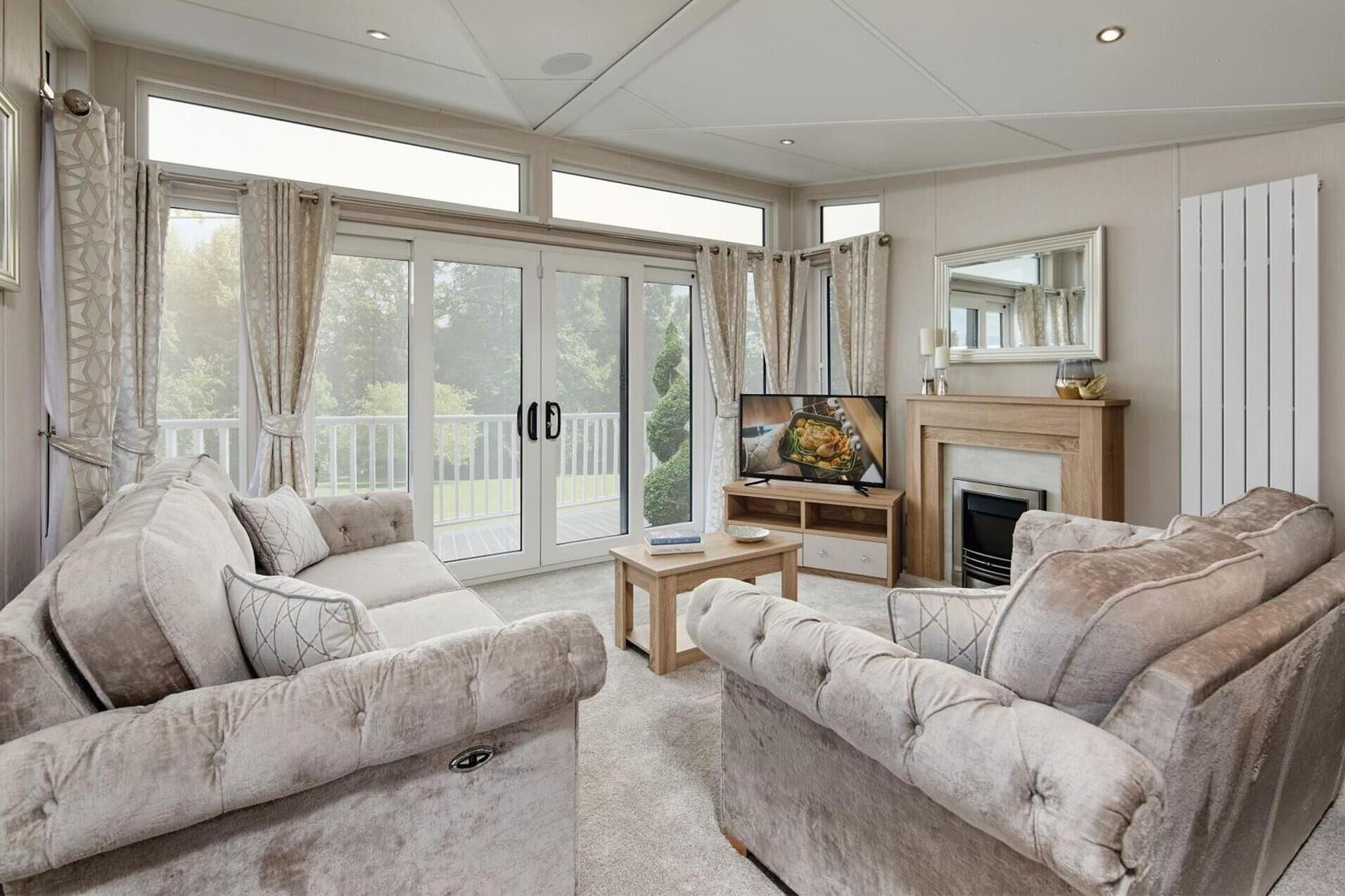 A spacious living room with a fireplace, two sofas, a coffee table, and a television.