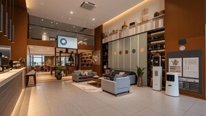 A spacious lobby with a modern design, featuring a seating area with sofas and a coffee table, a reception desk, and a large digital display. - WGSY Hotel (Hefei Economic Development Zone Mingzhu Square University Town) (Hefei)