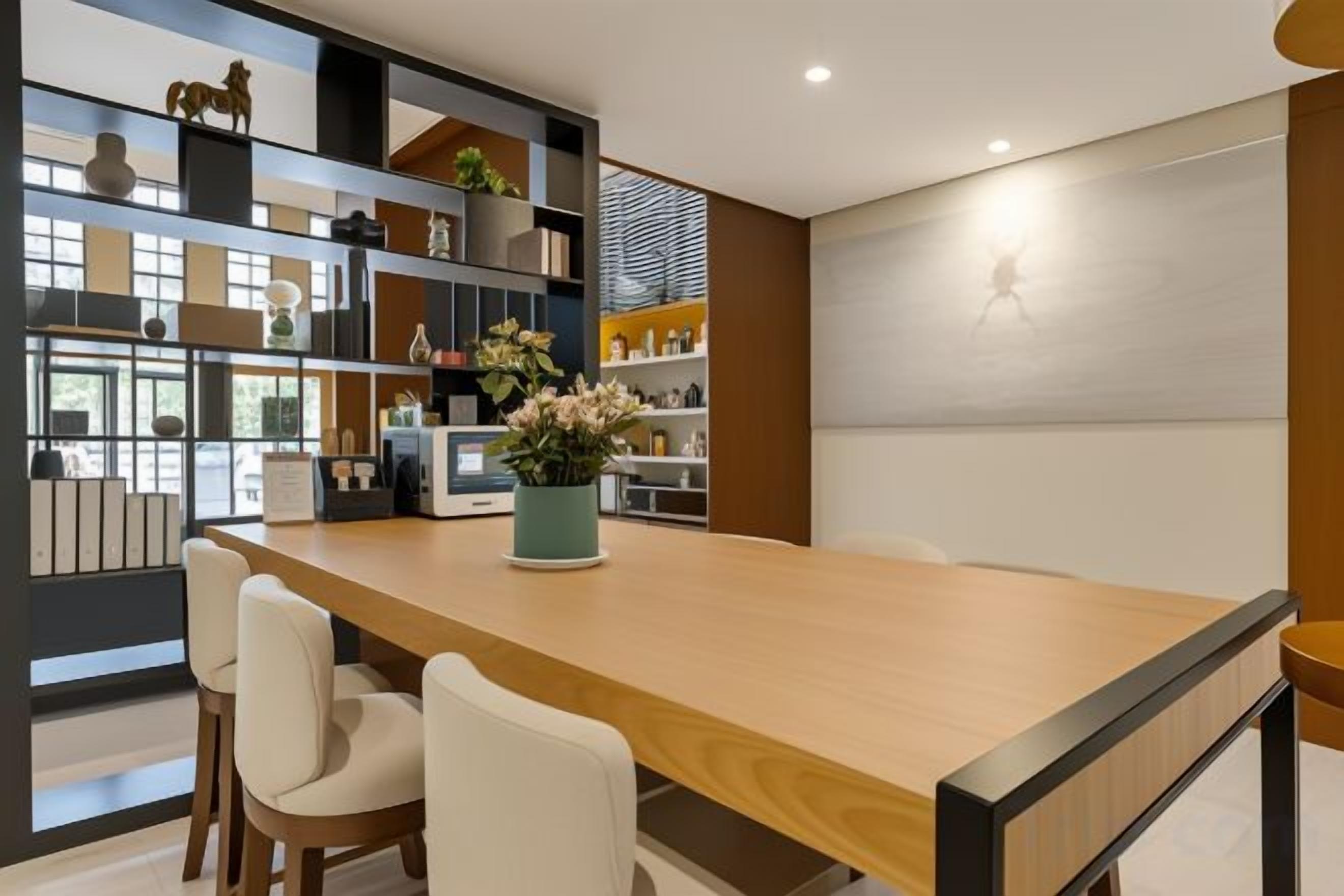 Une cuisine moderne avec un plan de travail en bois, des chaises blanches et une bibliothèque intégrée.
