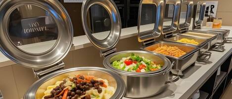 Un buffet proposant une variété de plats, notamment des pâtes, des salades et d’autres mets.