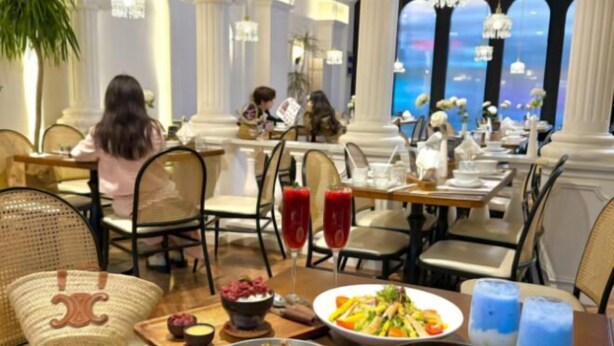 A restaurant with tables set for dining, a view of the city, and a variety of dishes on the tables. - WGSY Hotel (Hefei Economic Development Zone Mingzhu Square University Town) (Hefei)