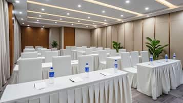 A conference room with rows of tables, chairs, and water bottles.