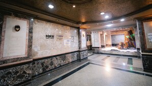 A lobby with marble walls and a central display area. - MAKAI Pyramids Guest House (Giza)
