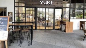 A restaurant named YUKI with a modern design, featuring a wooden facade and large glass windows. - Luxury Air Residences By Makati (Makati)