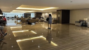 A spacious hotel lobby with a polished wooden floor, modern furniture, and a large seating area. - Luxury Air Residences By Makati (Makati)