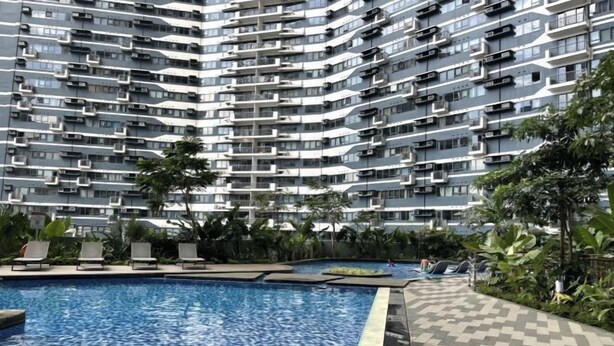 A modern high-rise building with a swimming pool and lounge area. - Luxury Air Residences By Makati (Makati)
