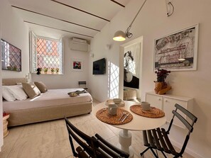 Une chambre à coucher moderne et bien éclairée, avec un lit, une table de chevet et une fenêtre donnant sur un beau paysage.