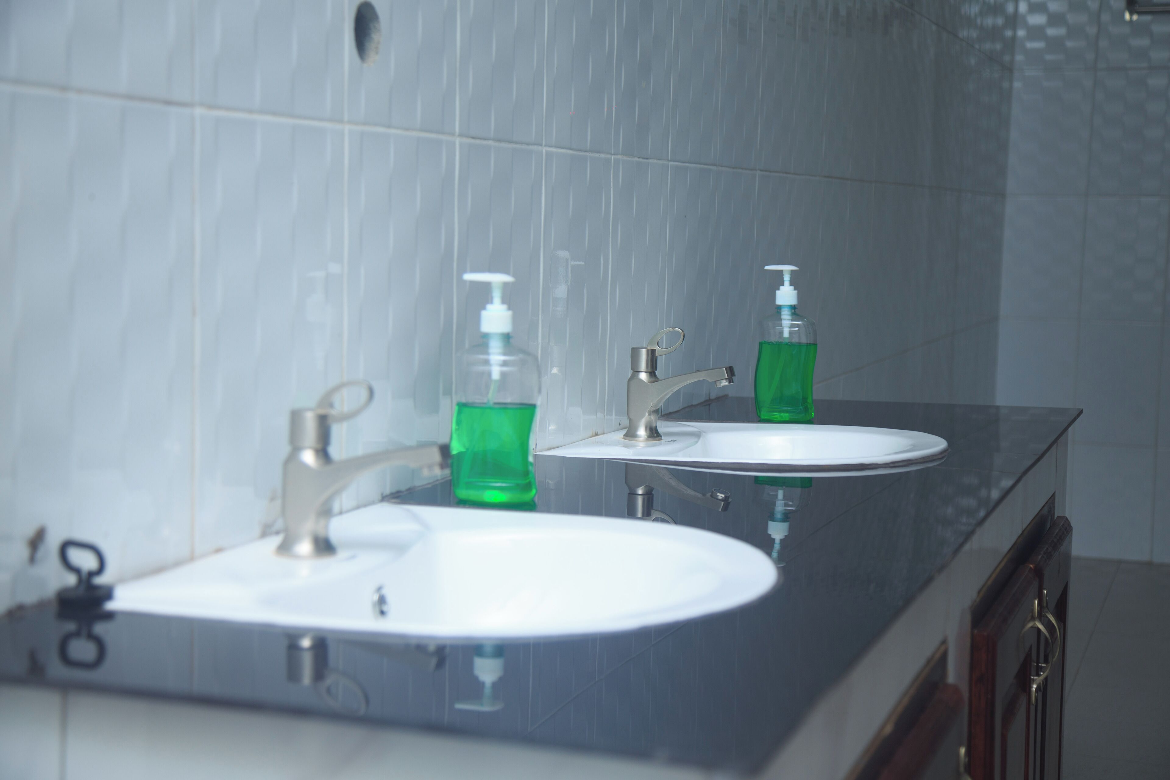 A bathroom with two sinks, a mirror, and a shower.