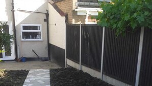 A garden area with a stone pathway leading to a house. - Single bedroom near London Seven Kings Train Station (Ilford)