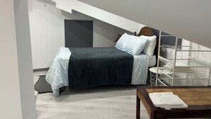 Une chambre à coucher avec un lit, une table en bois et une balustrade blanche.