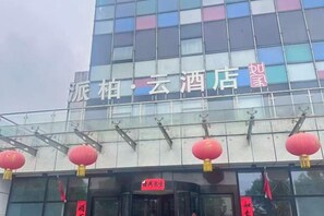 A hotel with a modern glass facade and red lanterns.