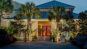 A hotel with a red entrance door, palm trees, and a parking lot. - 30A Driftwood/HotTub/Bikes/Close2Seaside (Santa Rosa Beach)