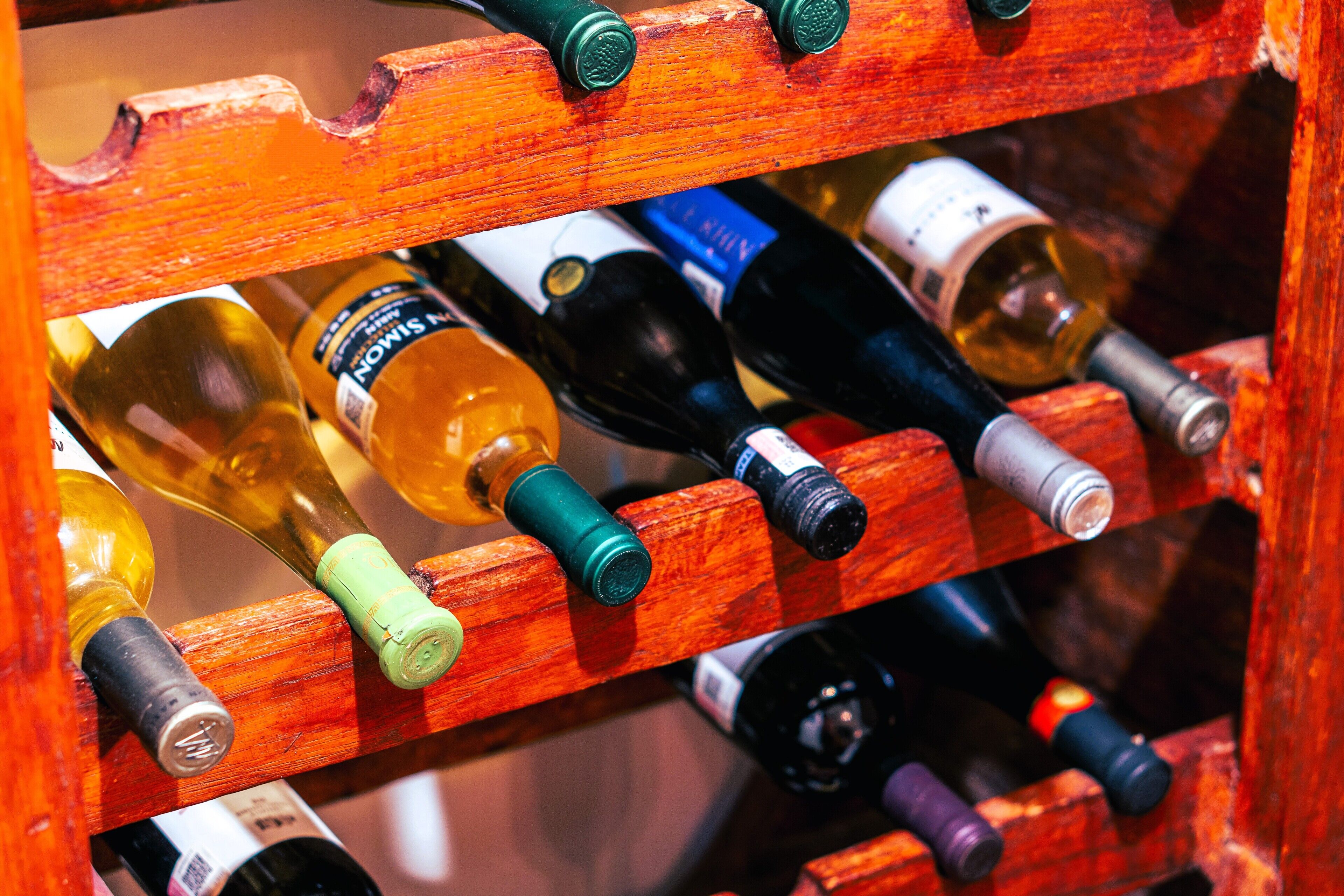 Una botellera de madera con varias botellas de vino.