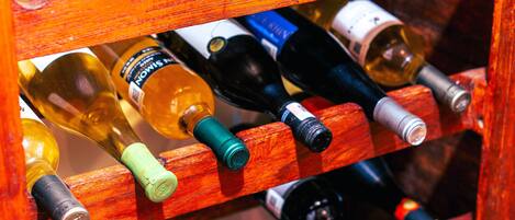 Una botellera de madera con varias botellas de vino.