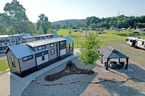 Un camping moderne pour véhicules récréatifs, doté de plusieurs emplacements, d’une aire de pique-nique couverte et d’un petit étang.