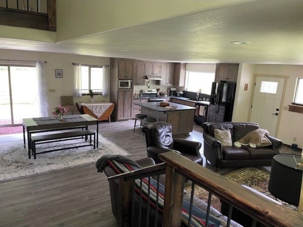 Relax in this stylish living area with a mezzanine level, featuring a sofa, armchair, and dining table.