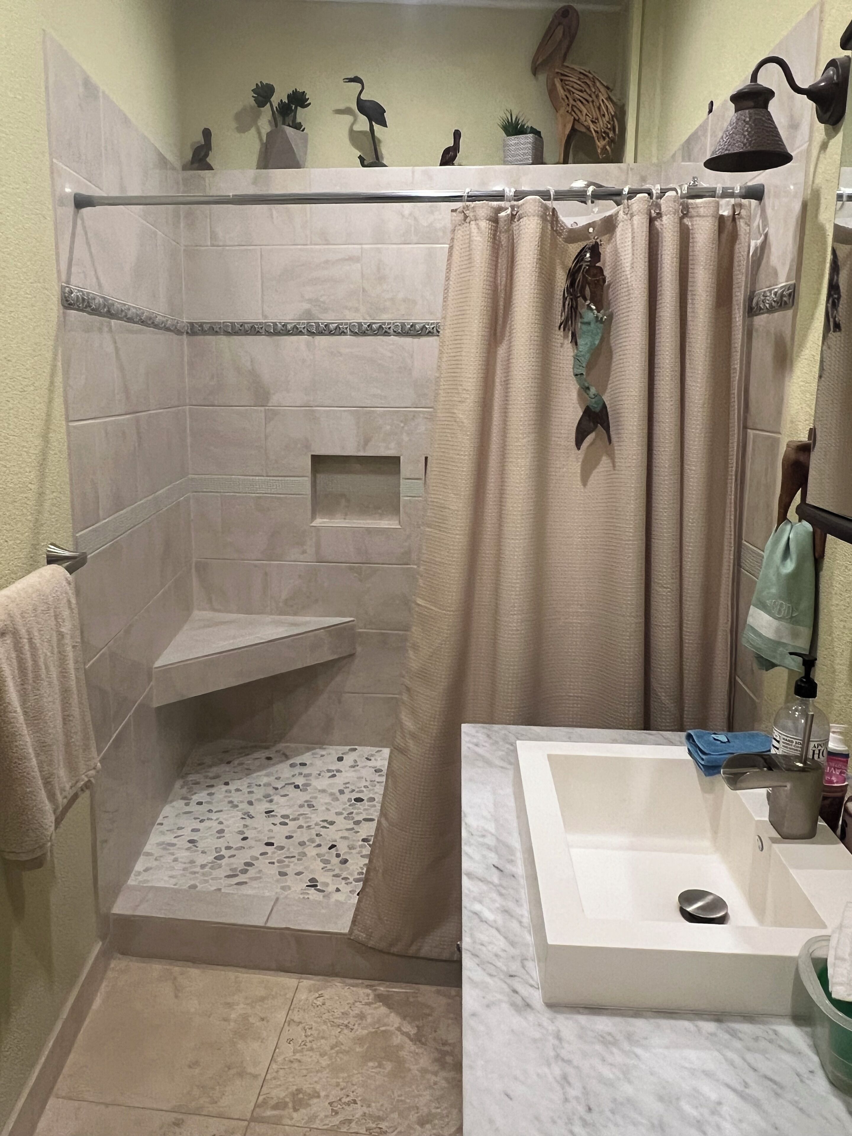 Un baño con ducha, lavabo y espejo.