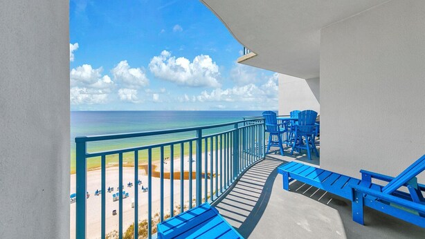 A balcony with a view of the beach and ocean.