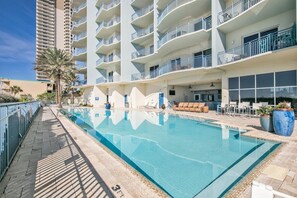 Enjoy a refreshing swim in the pool surrounded by lounge chairs and a bar area.