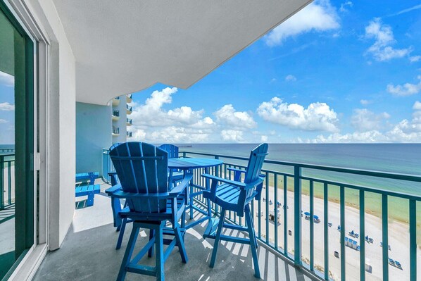 Enjoy the ocean view from this balcony with a table and two chairs.