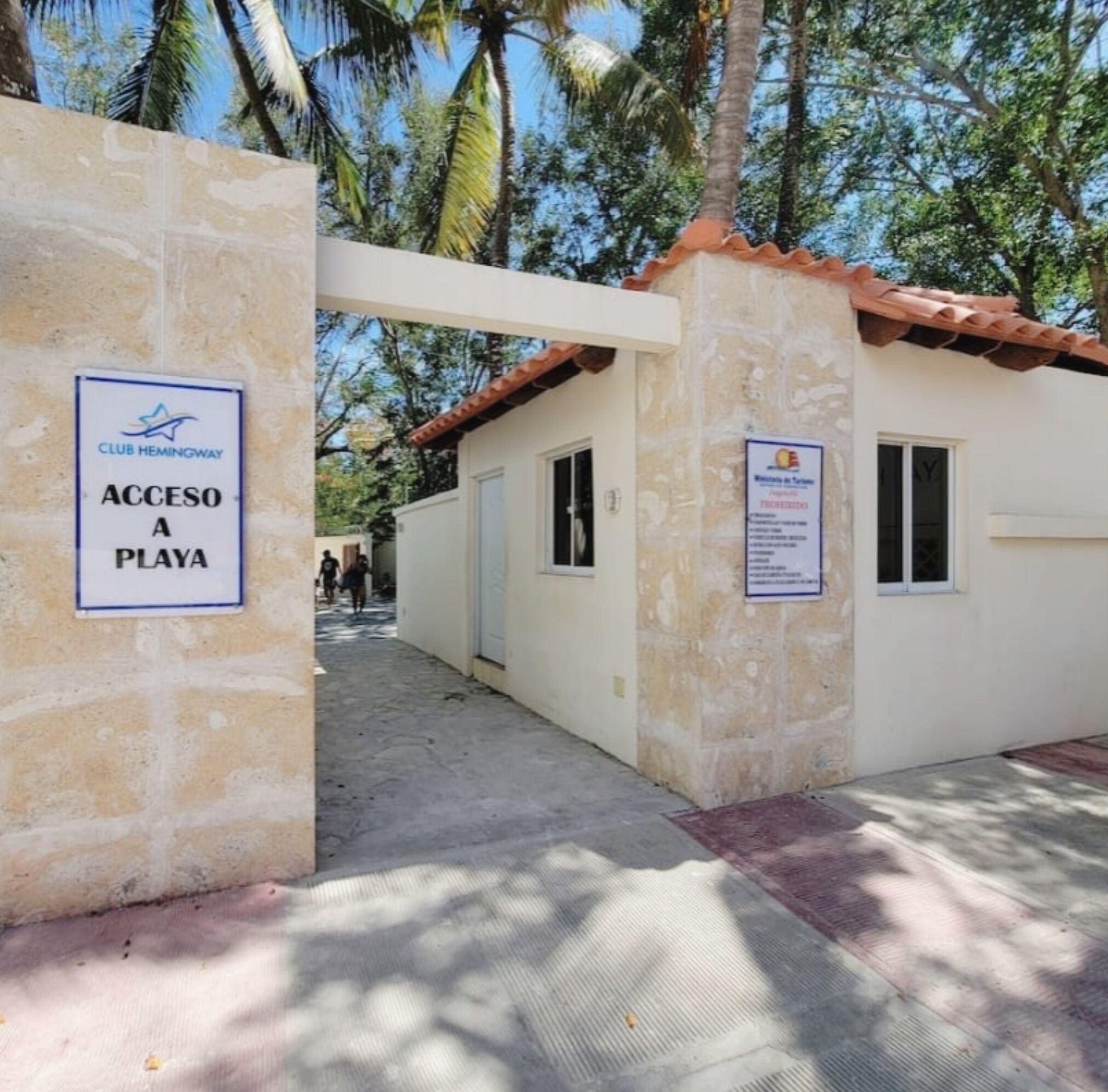 A Club Hemingway entrance with a sign indicating access to a beach.