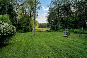 A well-maintained grassy lawn with a small shed and a bench in the center. - Serene Rustic Retreat with Lake (Cuddebackville)
