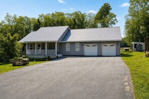 Une maison à deux étages avec un porche abrité et un garage.