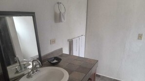 A bathroom with a sink, mirror, and towel rack.