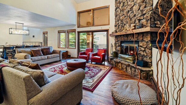 A spacious living room with a stone fireplace, comfortable seating, and large windows. - Spacious Keystone Family Escape Great Location (Keystone)