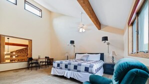 A bedroom with a bed, two bedside lamps, a ceiling fan, a large window, a dining table with chairs, and a mirror. - Spacious Keystone Family Escape Great Location (Keystone)