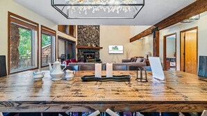 A spacious living room with a large wooden table, a fireplace, and a chandelier. - Spacious Keystone Family Escape Great Location (Keystone)