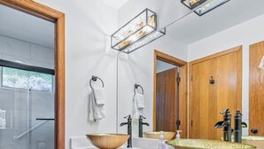 A modern bathroom with a large wooden vanity, two sinks, and a glass shower enclosure. - Spacious Keystone Family Escape Great Location (Keystone)