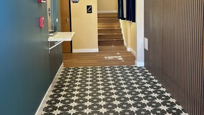 En hall med ett stjärnmönstrat golv, en trappa och en skylt som visar att det endast är tillträde för anställda.