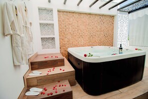 Un baño con una bañera de madera, una serie de escalones de madera y un perchero.