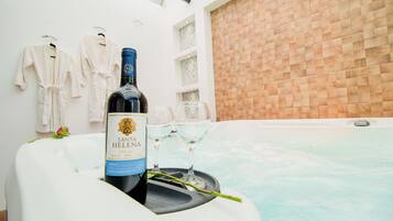Una botella de vino Santa Elena en una bañera con vasos y una rosa.