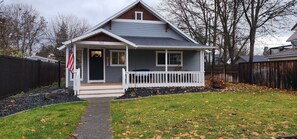 A single-story house with a front porch, a mailbox, and an American flag. - Guest Favorite, Peaceful, Walkable to Dinning & Shopping. 5-Star clean! (Coeur d'Alene)