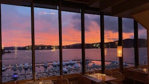 A restaurant with large windows overlooking a marina and a lake at sunset. - Guest Favorite, Peaceful, Walkable to Dinning & Shopping. 5-Star clean! (Coeur d'Alene)