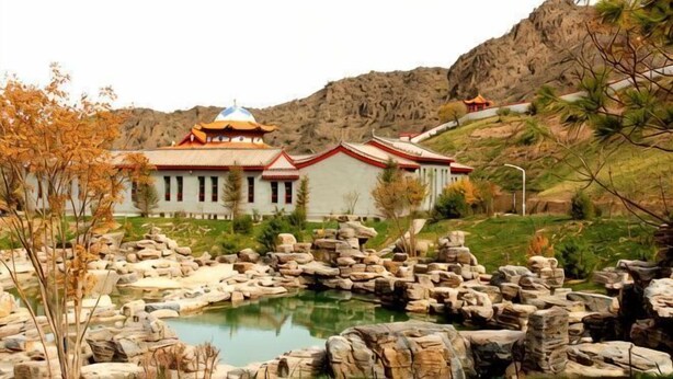 A traditional building with a prominent dome, surrounded by a rocky landscape and a small pond. - Helan Mountain Forest Park Visitor Service Center (Alxa Left Banner)