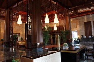Un vestíbulo con mostrador de recepción, zona de estar e iluminación decorativa.