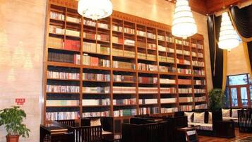 A library with bookshelves, seating, and a chandelier.