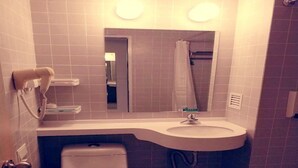 A compact bathroom with a toilet, sink, and a mirror above the sink. - Jinjiang Inn Shenyang North Station (Shenyang)